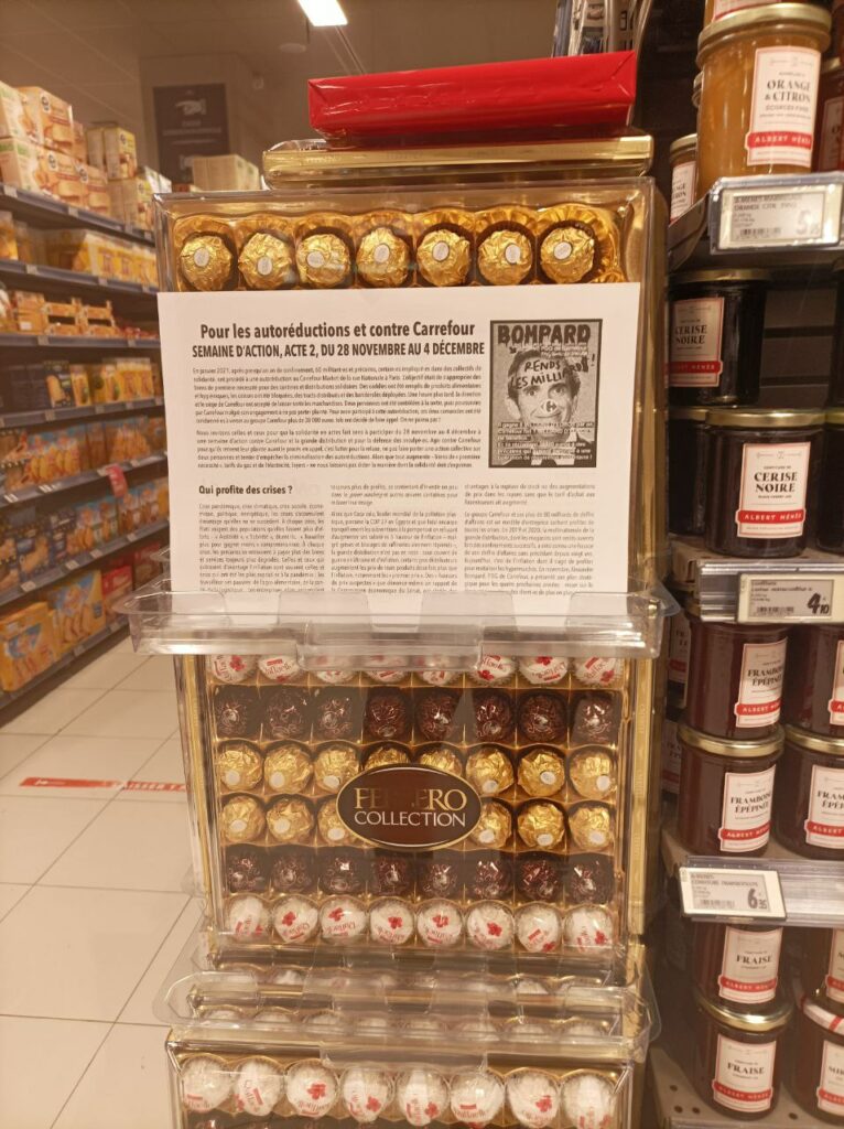 Photo du collectif Carrefour Retire Ta Plainte : 
Tête de gondole avec des chocolats, affichage du flyer expliquant les autoréductions (cf site).