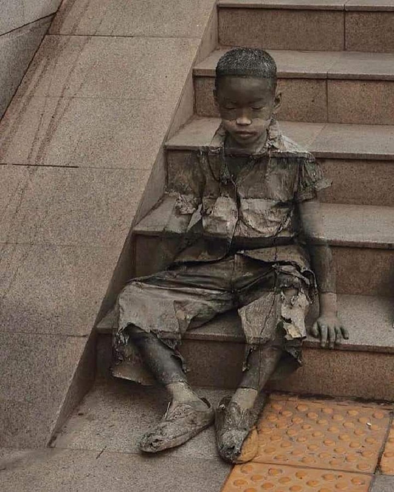 Street-art Kevin Lee "L'invisibilité de la pauvreté" 
Un enfant noir, visiblement pauvre au vu de ses haillons, assis sur des marches, se confondant avec elles.