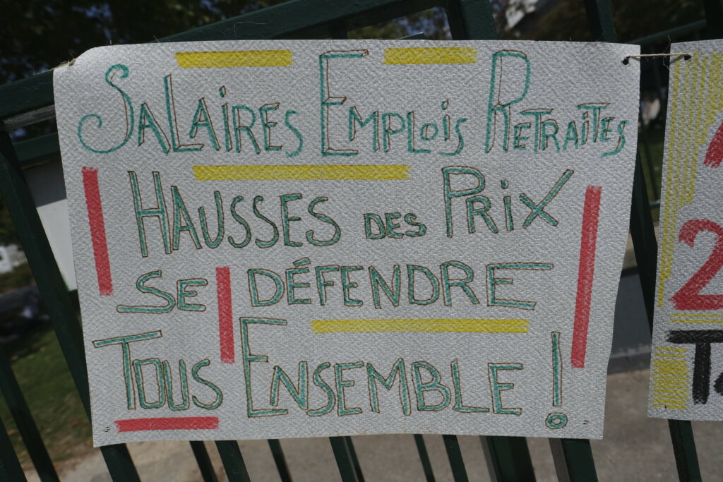 Photo de Serge D'Ignazio. Pancarte de manif : "Salaires, emplois, retraites, hausses des prix. Se défendre tous ensemble !"
