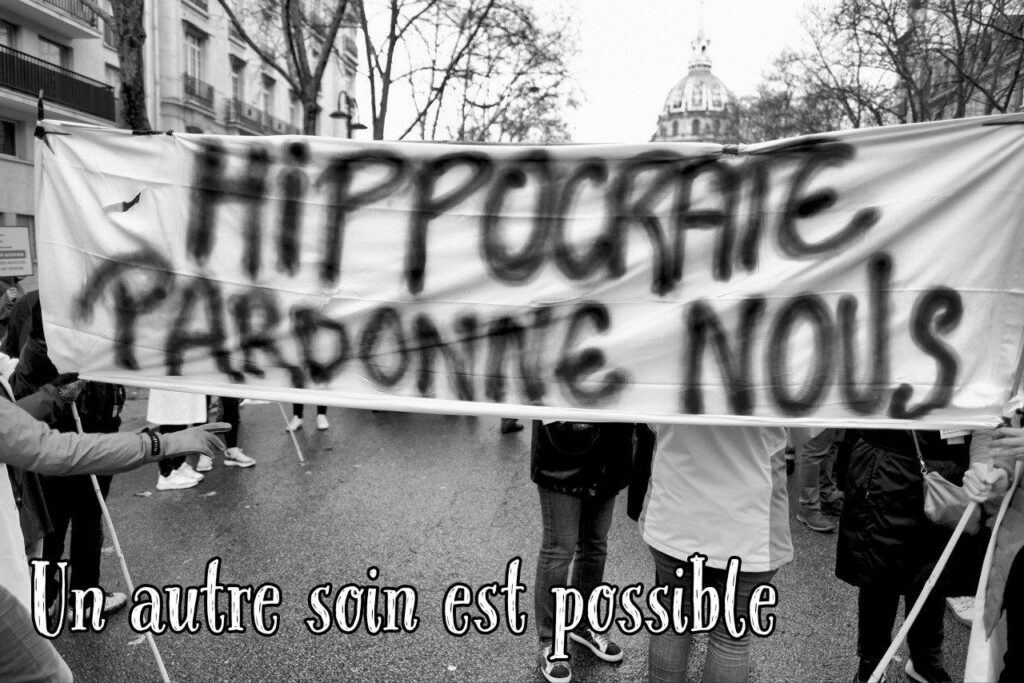 Des manifestant.e.s portent une pancarte où est écrit "Hippocrate pardonne-nous."
Nous avons ajouté : "Un autre soin est possible"