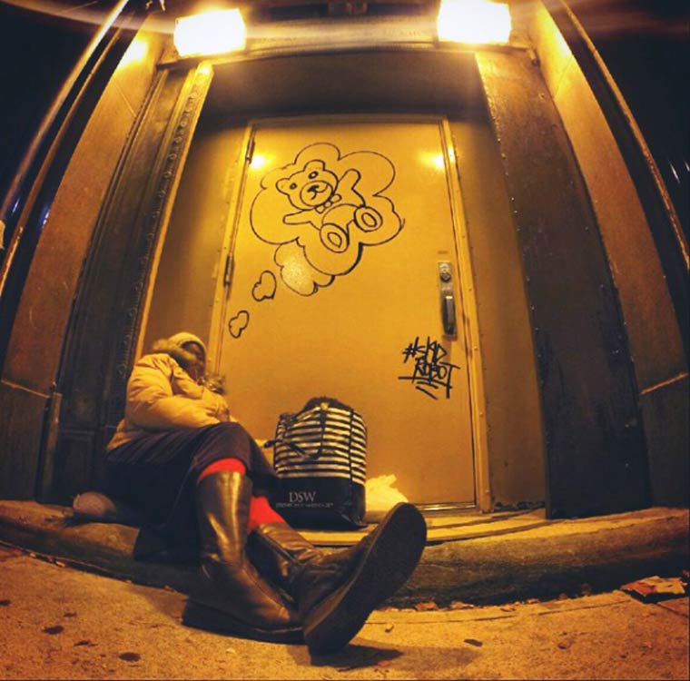 Photo de Skid Robot (street art) 
Femme sans domicile assise par terre devant une porte, la nuit. 
Sur la porte Skid Robot a dessiné (son rêve) : un nounours. 