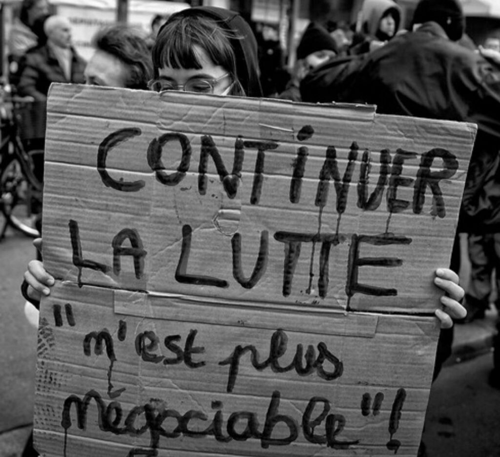 Photo d'une pancarte en manif où il est écrit "Continuer la lutte" n'est plus négociable "!
