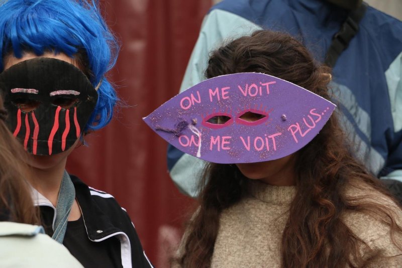 Photo de Dijoncter :
Une femme porte un masque sur lequel est inscrit "On me voit. On me voit plus..."