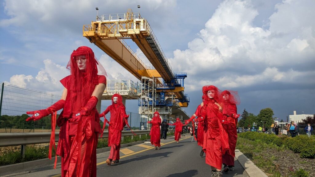 Photo du Collectif contre la ligne 18. On voit un groupe d'activistes d'Extinction Rébellion habillés en rouge. 