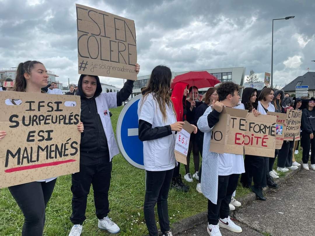 Photo de Télévision Loire 7. Groupe d'étudiantes et étudiants infirmiers en train de manifester avec des pancartes. On peut lire : "IFSI surpeuplés, EIS malmenés", "ESI en colère #JeSoigneraiDemain".