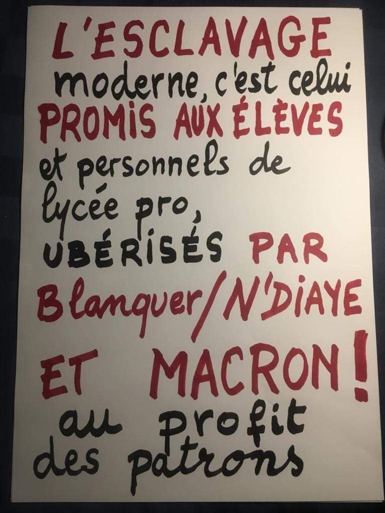 Sur une pancarte on peut lire écrit avec une alternance d'encre noire et rouge :
"L'esclavage moderne, c'est celui promis aux élèves et personnels de lycée pro, uberisés par Blanquer/ N'Diaye et Macron ! au profit des patrons".