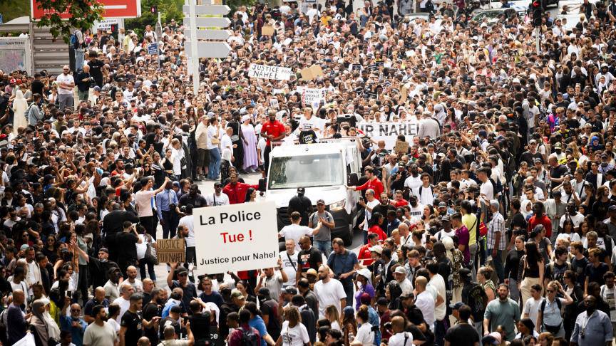 Photo (crédit inconnu) prise lors de la marche blanche pour Nahel. On y voit une grande foule. Au milieu, une pancarte : "La police tue".
