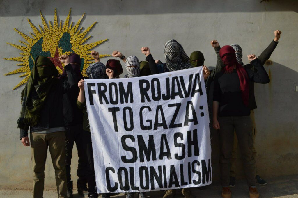Banderole "From Rojava to Gaza : smash colonialism". (du Rojava à Gaza brisons le colonialisme"). 