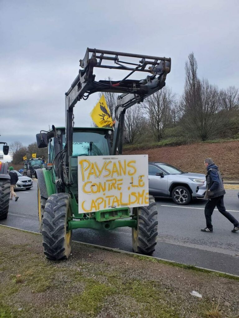 Tracteur avec drapeau de la Conf et pancarte "Paysans contre le capitalisme".