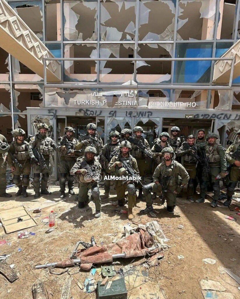 Photo de soldats israéliens posant devant un hôpital détruit. 