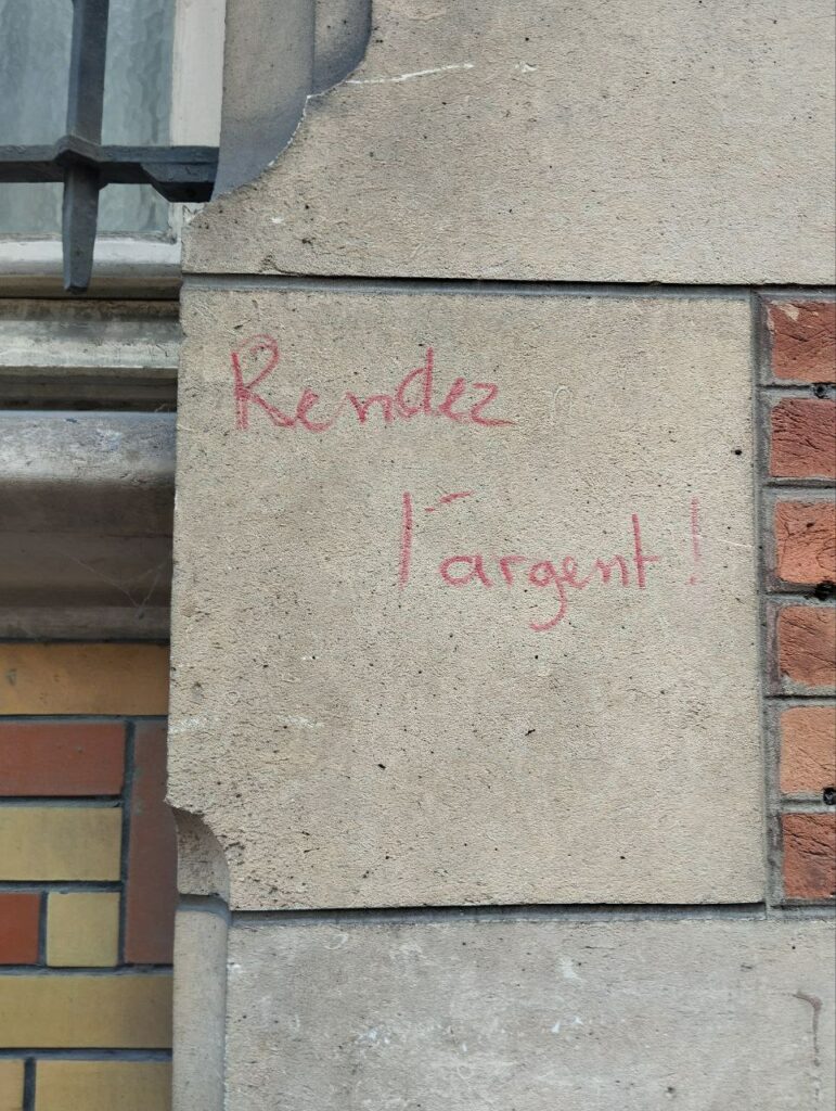 Photo d'un tag sur un mur : "Rendez l'argent ! "